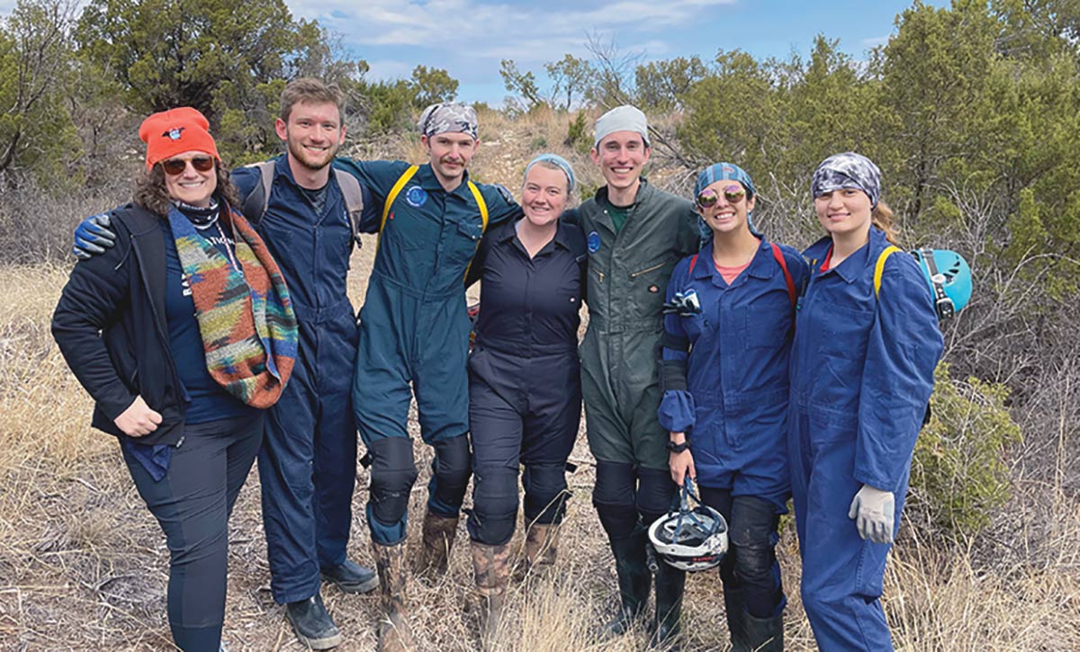 Texas A&M students smile and pose for a picture together outside during the day as they spent their spring break learning about and assisting with bat research.