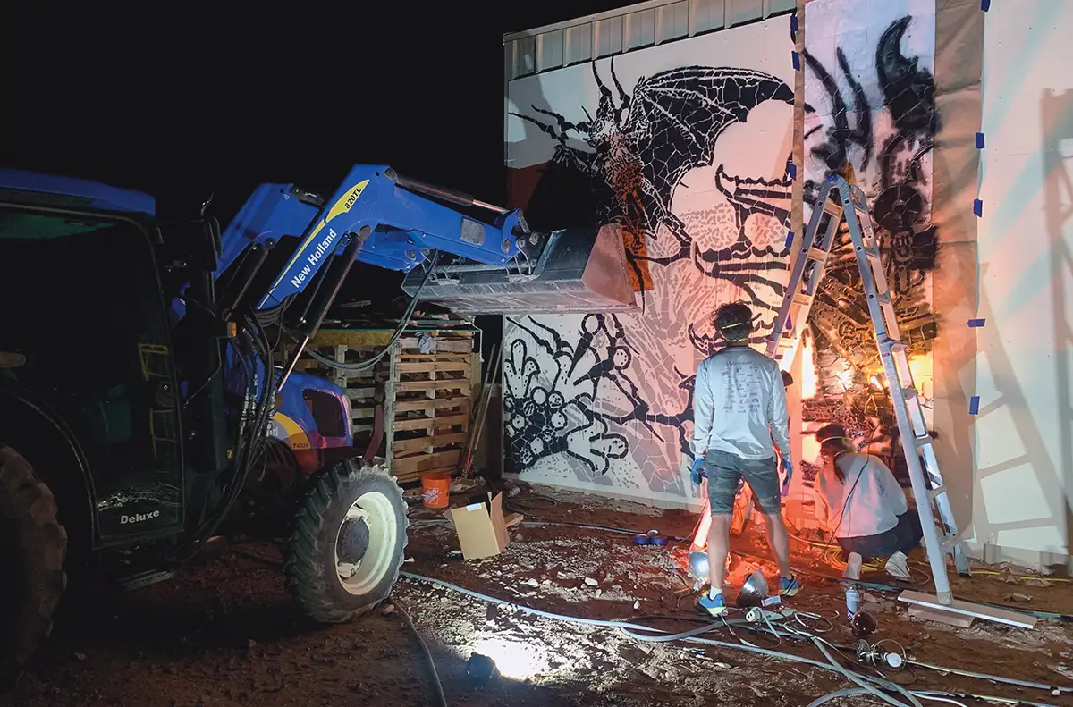 HOKZYN and Dominic working on a bat mural at night