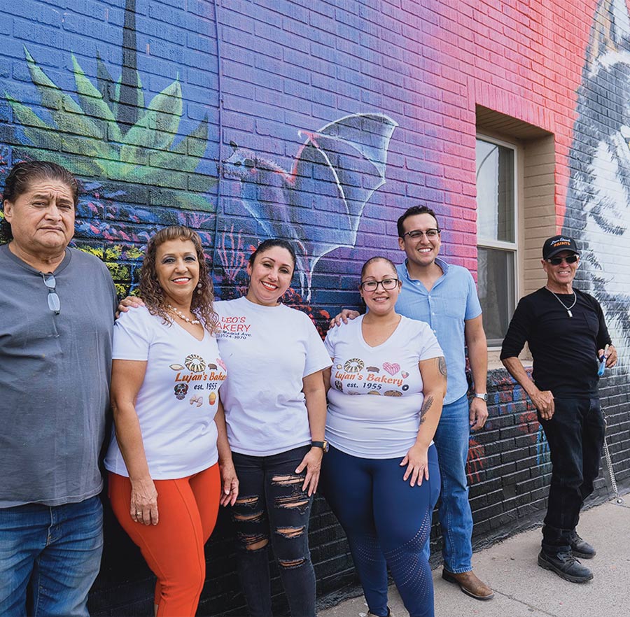 community members smiling in front of the Las Cruces mural