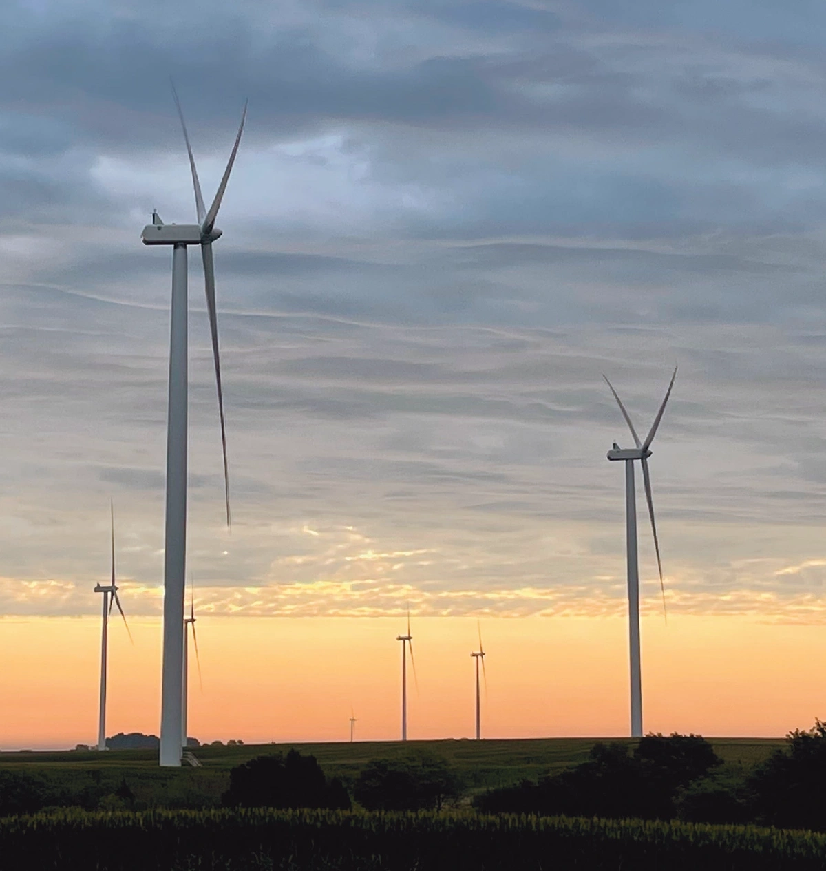 wind turbines during sunset with cloudy sky