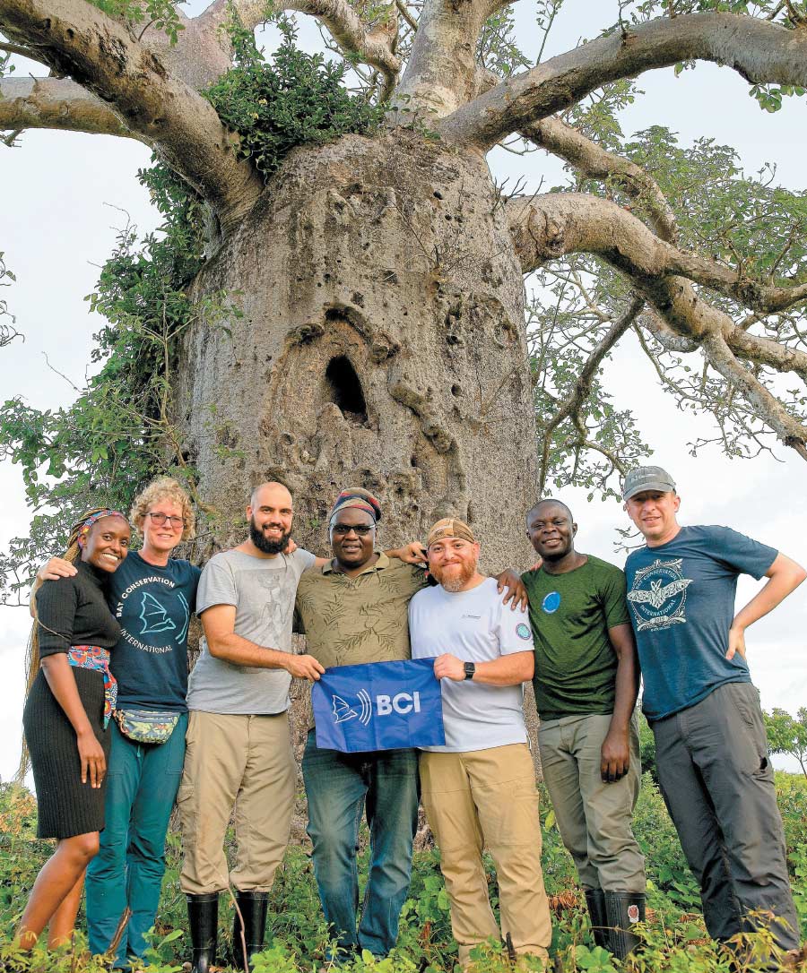 BCI team smiling for group photo in front of tree in coastal Kenya