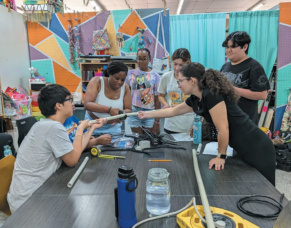 A group of people working together at a table in a colorful creative workspace.