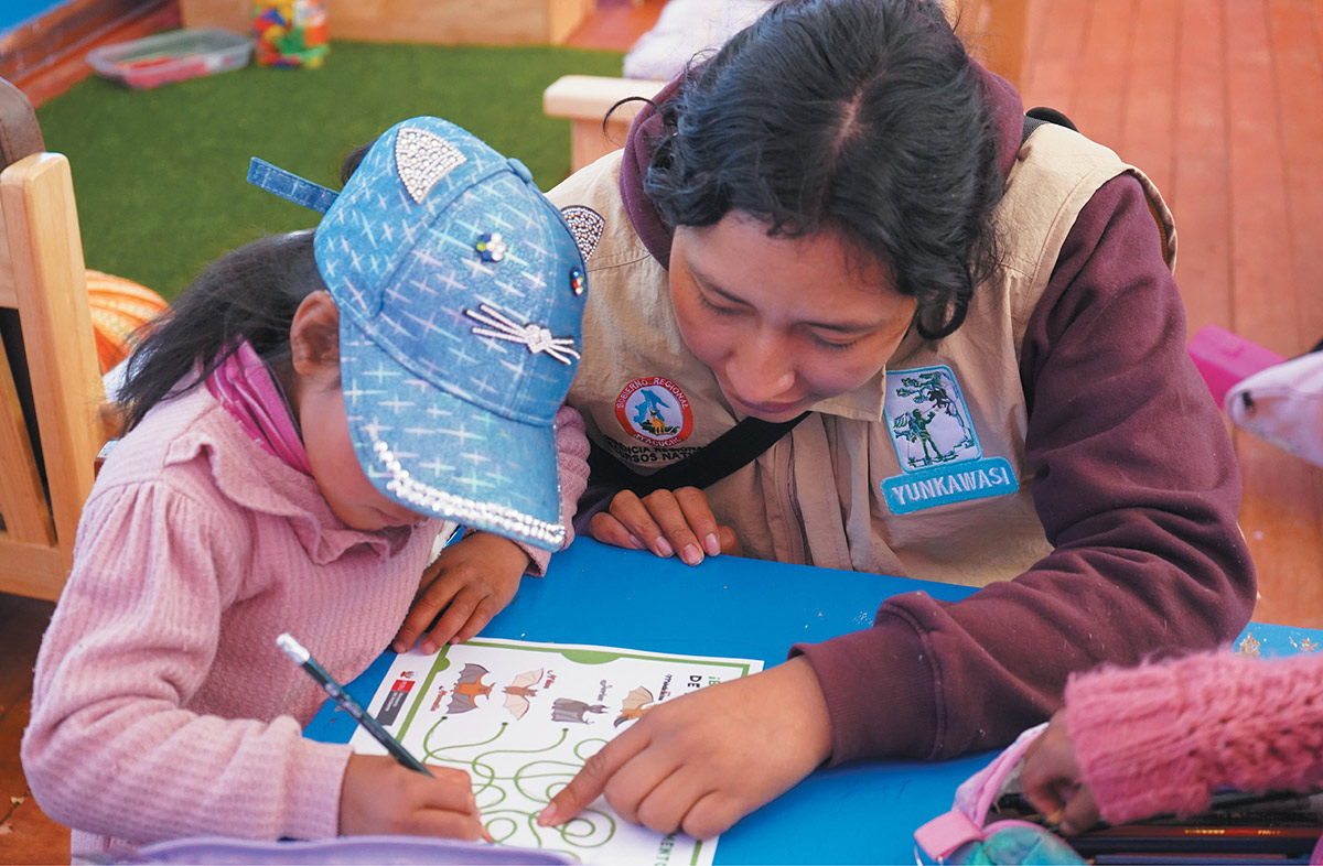 female Yunkawasi team member helping child with workshop