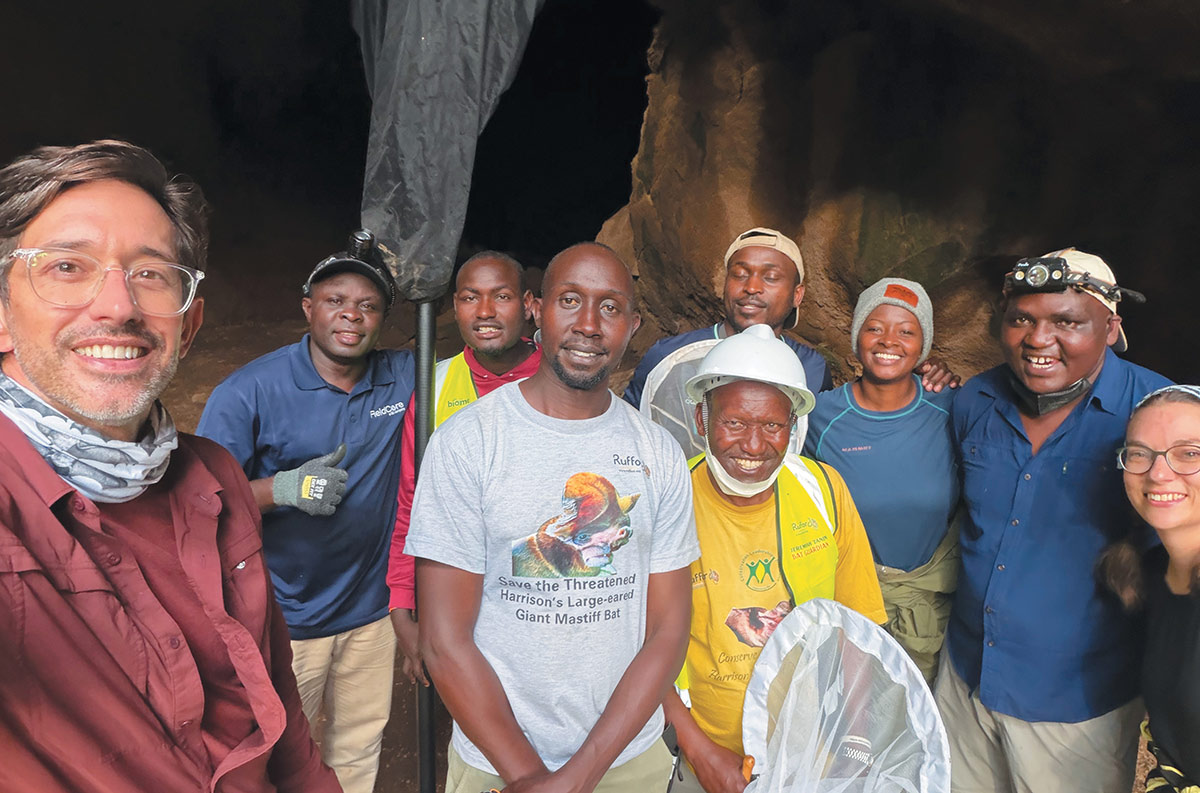Group of researchers and team members standing together inside a cave for bat conservation.
